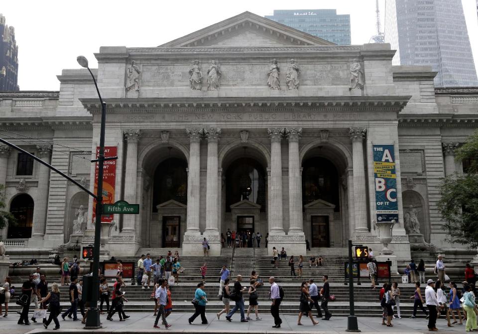 In this Monday, July 22, 2013 photo, pedestrians walk past the main branch of the New York Public Library in New York, Monday, July 22, 2013. Plans for a major change within the New York Public Library’s landmark main building have kindled an intellectual culture clash over its direction and the future of libraries themselves. (AP Photo/Seth Wenig)