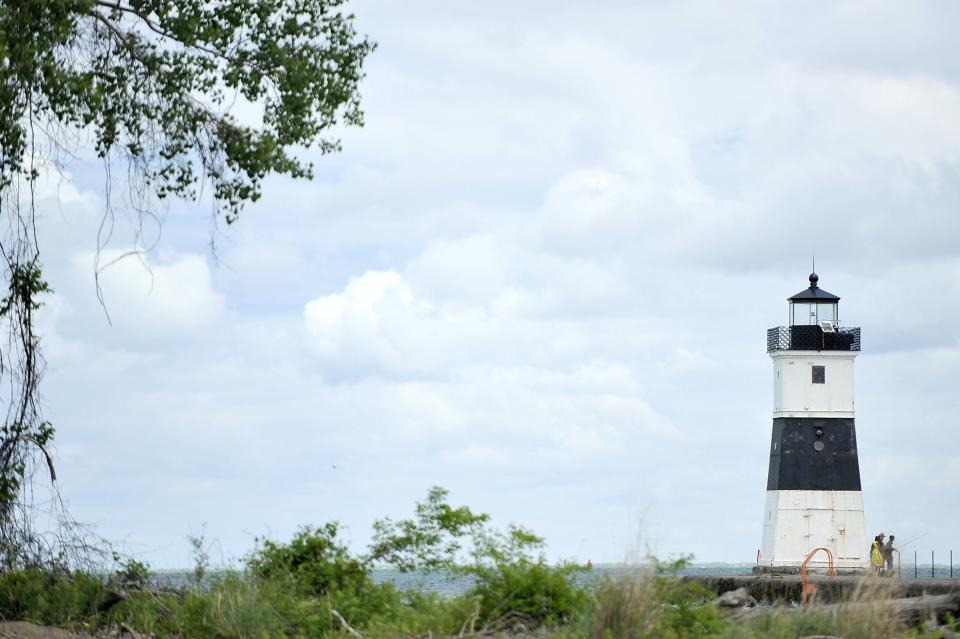 People fish beside Presque Isle North Pier Lighthouse at Presque Isle State Park. The lighthouse has been guiding mariners since 1857.