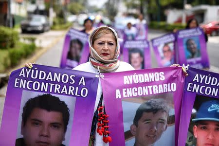 A woman holds banners with pictures of missing persons during a march to mark Women's Day in Xalapa, in the state of Veracruz, Mexico May 10, 2018. REUTERS/Yahir Ceballos