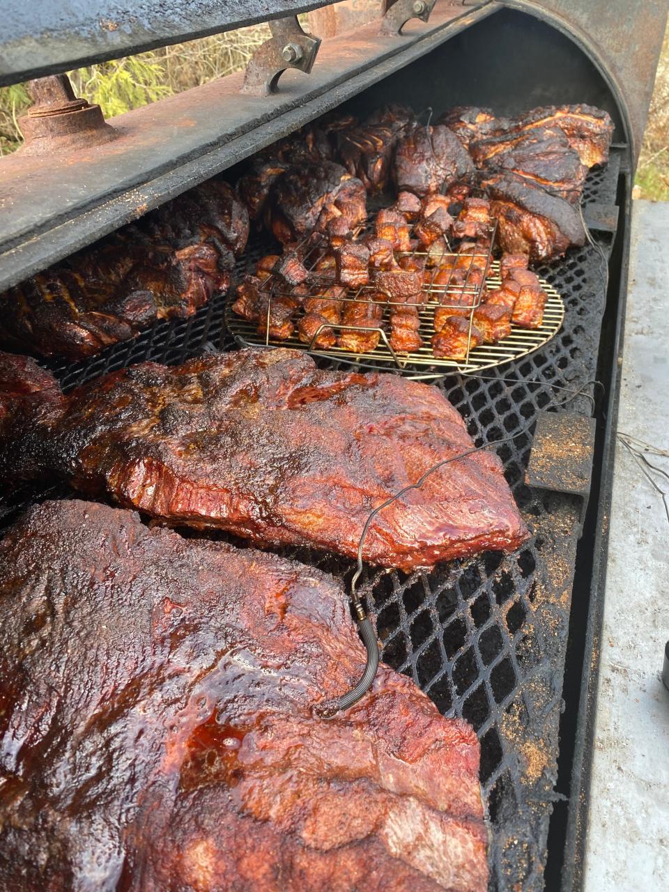 A variety of Heavy Smoker BBQ meat cooks on a smoker.