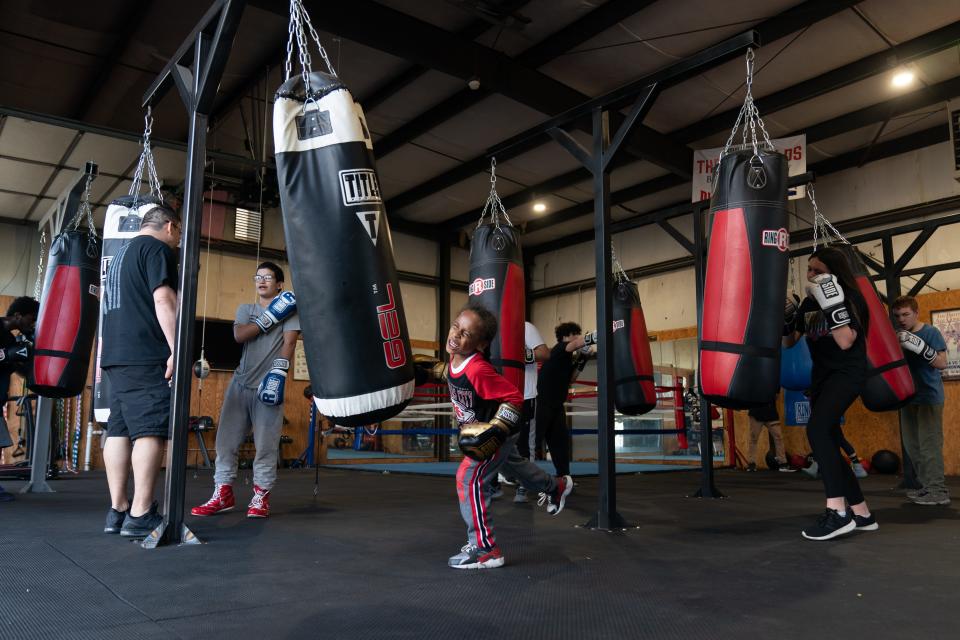 Amire Roberts, 7, puts all of his strength into punching a bag along with other youths at Three Shields Boxing Academy. The eight-week program is open to youths 5-18 years old.