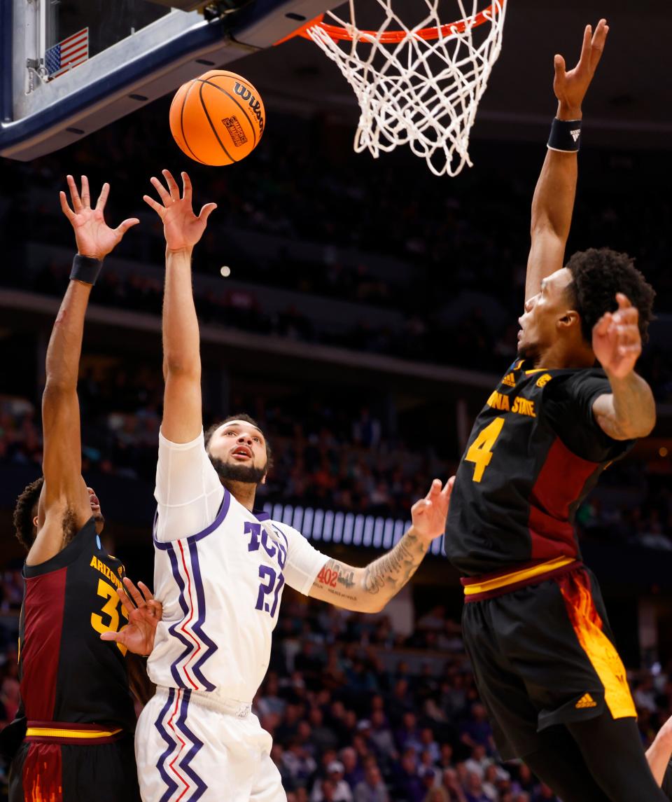 TCU Horned Frogs forward JaKobe Coles (21) shoots against Arizona State Sun Devils guard Desmond Cambridge Jr. (4) and forward Alonzo Gaffney (32) during the first half at Ball Arena in Denver on March 17, 2023.