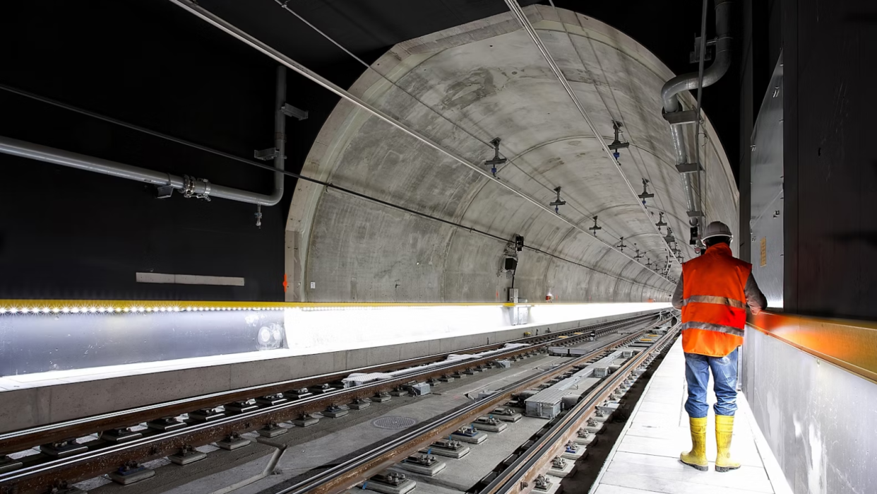  A man using a tablet in a tunnel that's being engineered. 