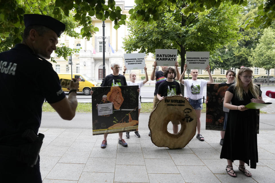 Greenpeace activists hold a news conference in Warsaw, Poland, on Wednesday June 21, 2023 outside the office of the Polish prime minister asking him to act to reduce logging in the Carpathian Mountains. Greenpeace said in a recent report that a forested area the size of five soccer fields disappears every hour from the Carpathians, which runs through parts of Poland, Slovakia, Hungary, Romania and Ukraine. (AP Photo/Czarek Sokolowski)