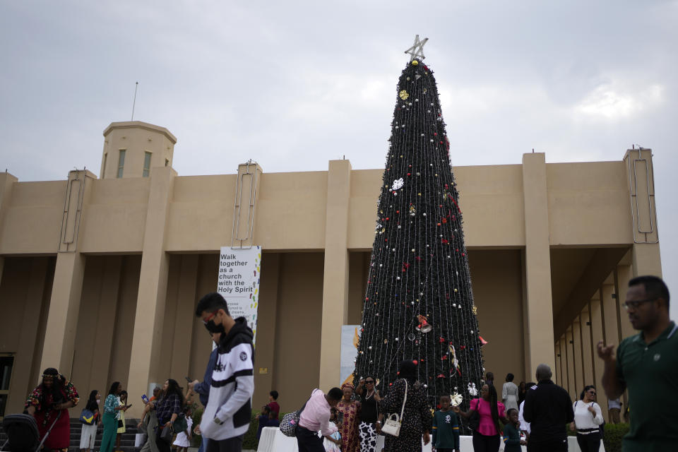 People take photographs in front of a Christmas tree outside the Catholic Church, Our Lady of the Rosary, at the Religious complex, in Doha, Qatar, Friday, Dec. 9, 2022. (AP Photo/Thanassis Stavrakis)