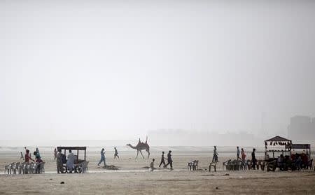 Residents walk along the beach on a hot summer day in Karachi, Pakistan, May 20, 2016. REUTERS/Akhtar Soomro - RTSF65K