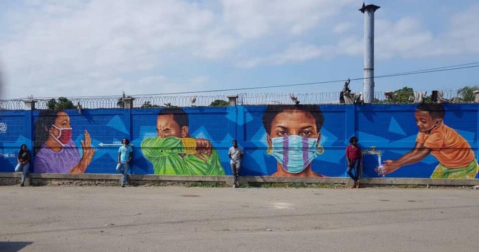 Haitians fleeing the Dominican Republic because of COVID-19 and arriving in Ouanaminthe, just outside of Cap-Haitien, are greeted by the newly painted mural reminding them to wear a mask and cover their face when they sneeze.