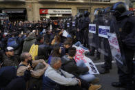 Pro independence demonstrators block a road, during a sit-down protest outside the Barcelona office of the state prosecutor, in Barcelona, Spain, Tuesday, Feb. 12, 2019. A sensitive trial against a dozen Catalan separatist politicians and activists got underway Tuesday in Spain's Supreme Court amid protests by pro-independence supporters and a highly volatile political environment. (AP Photo/Daniel Cole)