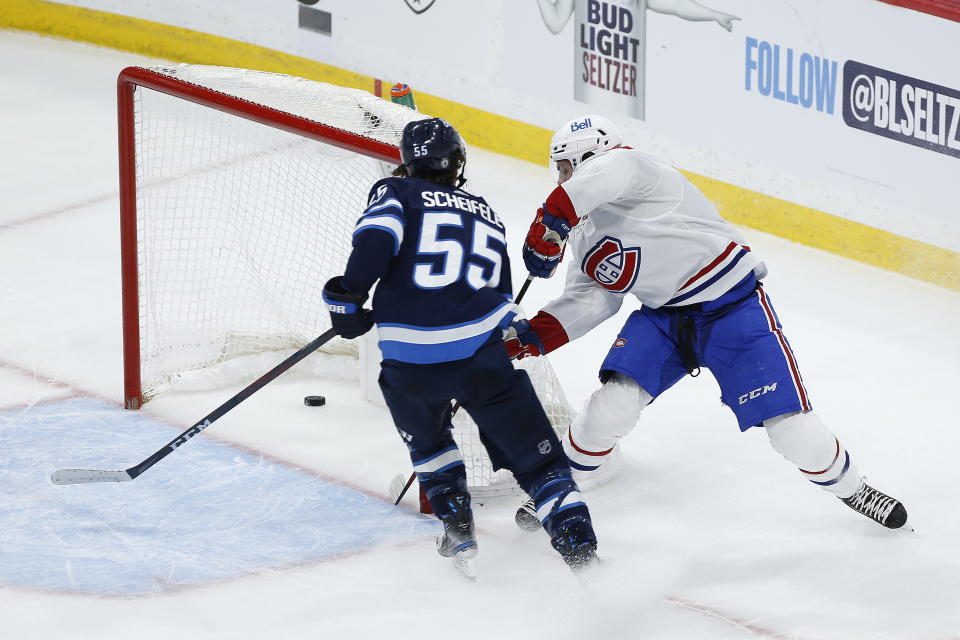 Montreal Canadiens' Jake Evans (71) scores an empty-net goal as Winnipeg Jets' Mark Scheifele (55) defends during the third period of Game 1 of an NHL hockey Stanley Cup second-round playoff series Wednesday, June 2, 2021, in Winnipeg, Manitoba. (John Woods/The Canadian Press via AP)