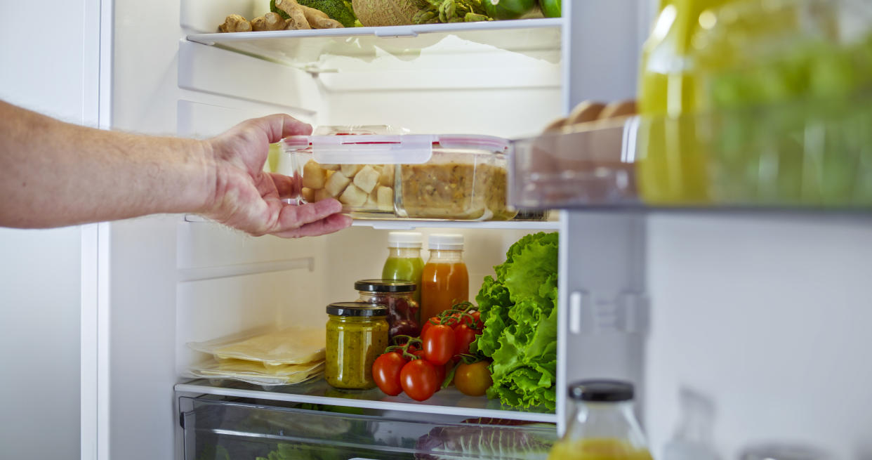 hand taking a fridge organizer out of a neat-looking fridge