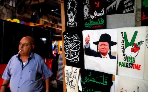 A T-shirt bearing an image of US President Donald Trump dressed as a Hasidic Jew is displayed in a souvenir shop in Jerusalem's Old City - Credit:  AHMAD GHARABLI/ AFP