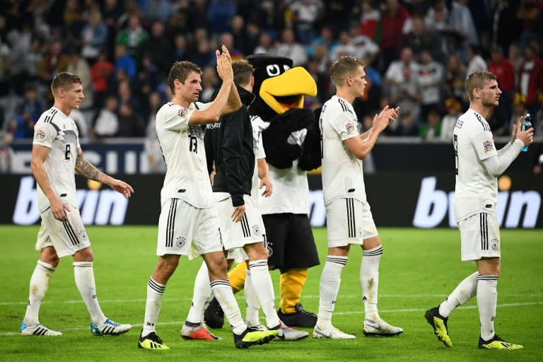 Toni Kroos (L) and Thomas Mueller (2ndL) take the applause from the German fans after Thursday's draw with France