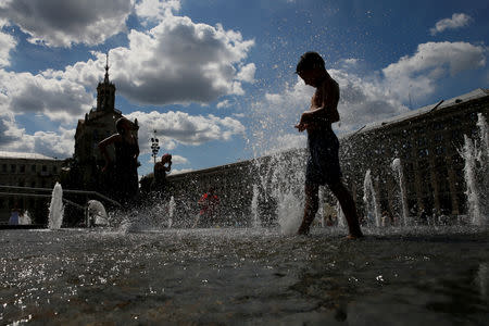 A boy plays in a fountain on a hot summer day in central Kiev, Ukraine August 8, 2018. REUTERS/Valentyn Ogirenko