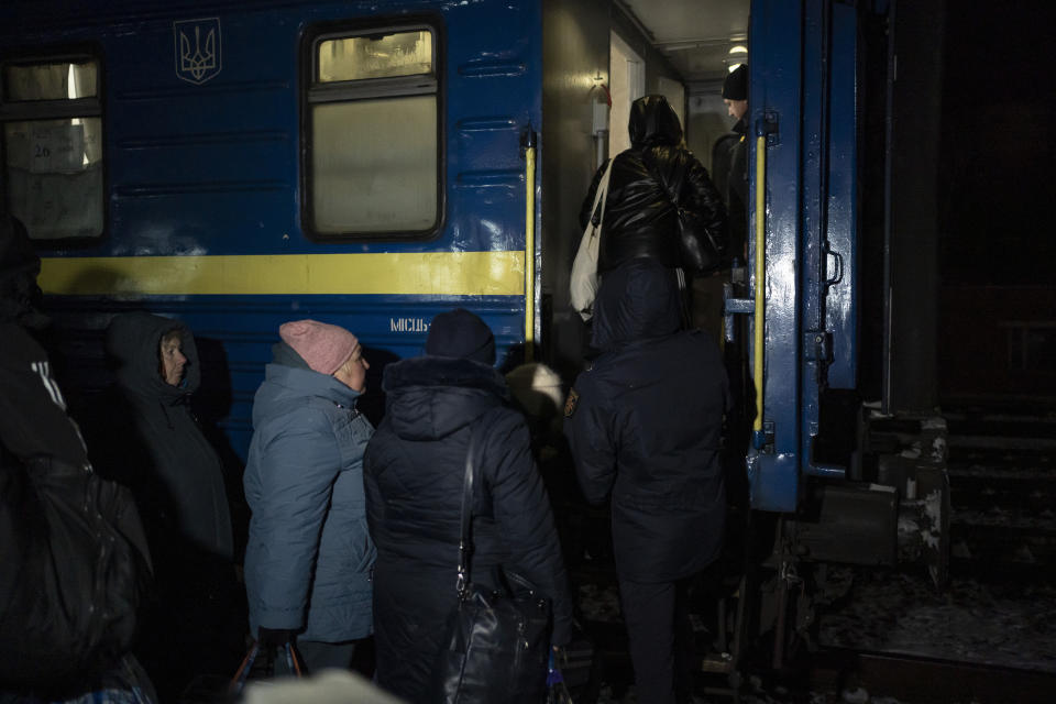 People carrying their luggage board an evacuation train in Sumy, Ukraine, Thursday, Nov. 23, 2023. An average of 80-120 people return daily to Ukraine from territories held by Russia through an unofficial crossing point between the two countries amid a brutal war. Most choose this challenging path, even in freezing temperatures, to escape Russian occupation and reunite with their relatives in Ukraine. (AP Photo/Hanna Arhirova)