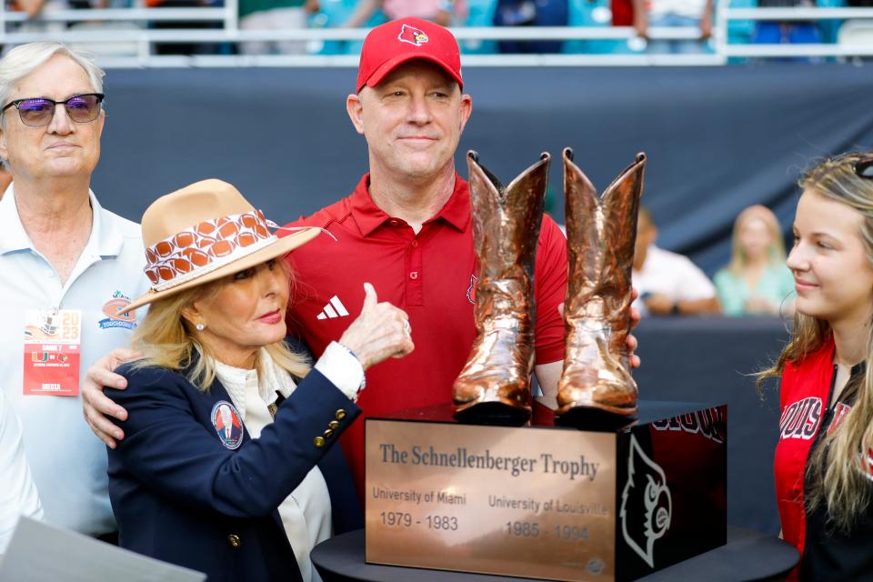 Nov 18, 2023; Miami Gardens, Florida, USA; Louisville Cardinals head coach Jeff Brohm is photographed with The Schnellenberger Trophy after winning the game against the Miami Hurricanes at Hard Rock Stadium. Mandatory Credit: Sam Navarro-USA TODAY Sports