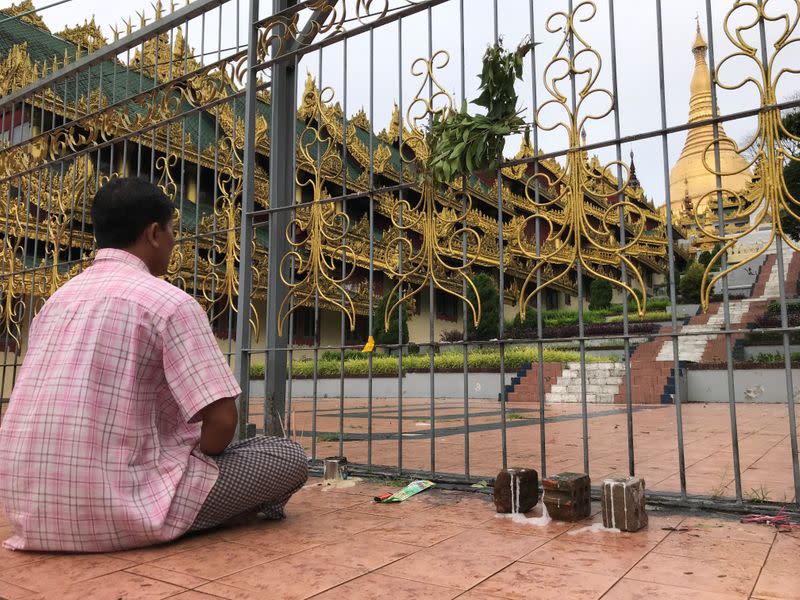 Taxi driver Ko Naing prays in front of closed Shwedagon Pagoda in Yangon