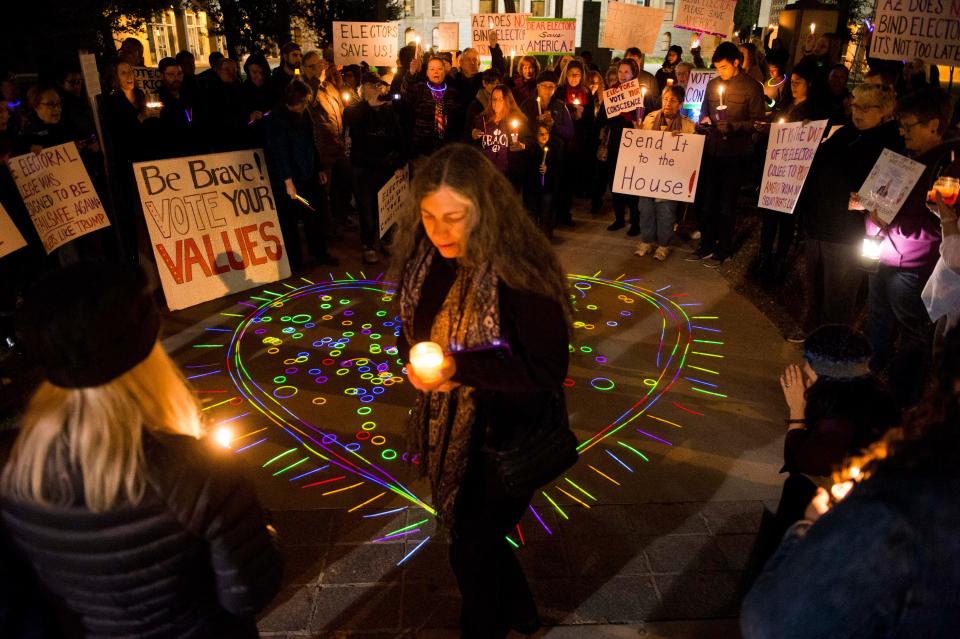 Rena Weiss of Tucson, Arizona, joins a vigil at the Arizona State Capitol in Phoenix to urge members of the Electoral College to cast their votes for anyone other than President-elect Donald Trump in 2016.