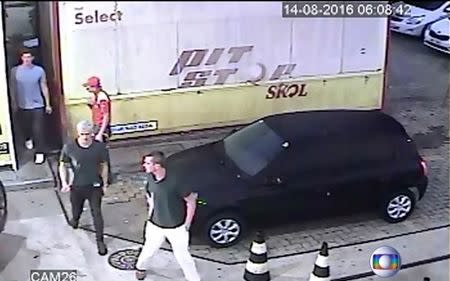 Security video shows three U.S. Olympic swimmers returning from a bathroom to their taxi at a gasoline station where they were accused by staff of having caused damage, in Rio de Janeiro, August 14, 2016. Courtesy Globo TV/Handout via Reuters