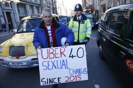 A London cab driver holds a placard during a protest by London cab drivers against Uber in central London, Britain February 10, 2016. REUTERS/Stefan Wermuth