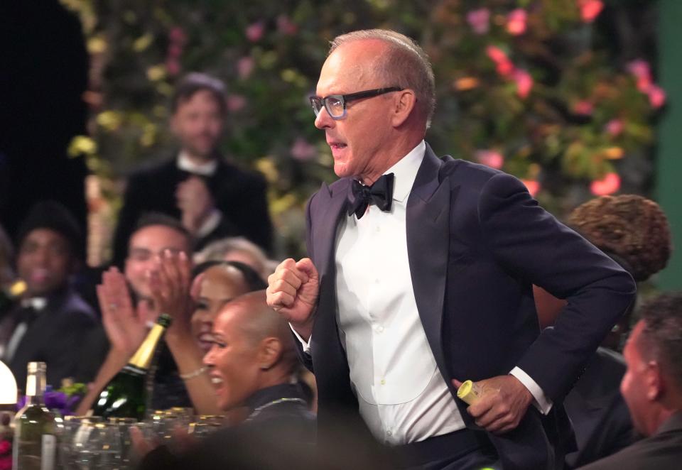 An image of Michael Keaton running to accept his award.