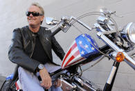 FILE - In this Oct. 23, 2009, file photo, Peter Fonda, poses atop a Harley-Davidson motorcycle in Glendale, Calif. Fonda, the son of a Hollywood legend who became a movie star in his own right both writing and starring in counterculture classics like "Easy Rider," has died. His family says in a statement that Fonda died Aug. 16, 2019, at his home in Los Angeles. He was 79. (AP Photo/Chris Pizzello, File)