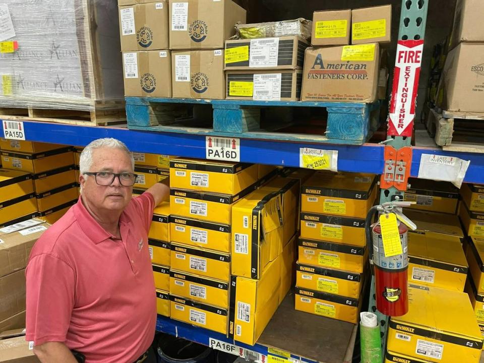 Manny Benitez, president of American Fasteners Corp., poses before Ultracon screws in the company’s Doral warehouse. He said that last summer he lost some sales to a competitor selling imitation Ultracon screws for lower prices.