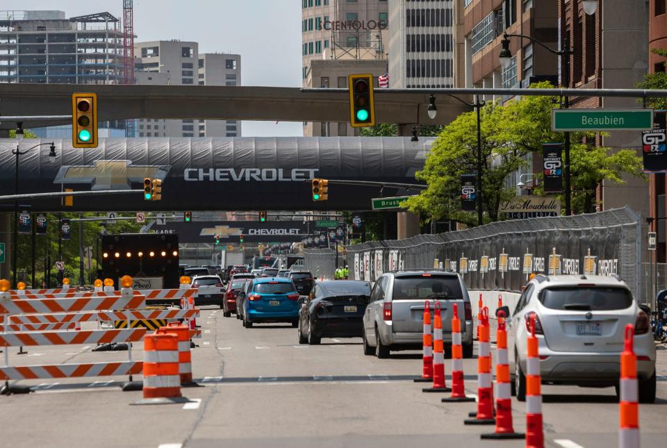 Cars drive down Jefferson Avenue as orange plastic drums and delineator posts are spread through parts of Jefferson Avenue in preparations for the Detroit Grand Prix in downtown Detroit on Wednesday, May 24, 2023. 