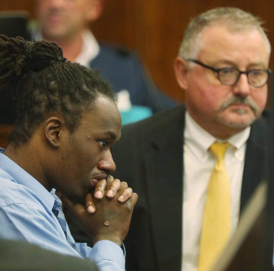 Defendant Leon Newsome and defense attorney John Greven look at photos as an Akron Fire Department investigator testifies in Newsome's trial for starting a fire that killed two people in Summit County Common Pleas Judge Tammy O'Brien's courtroom in Akron.