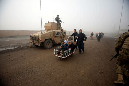 Displaced people pass Iraqi soldiers as they flee their homes during a battle with Islamic State militants in Arabi neighborhood, north of Mosul. REUTERS/Khalid al Mousily