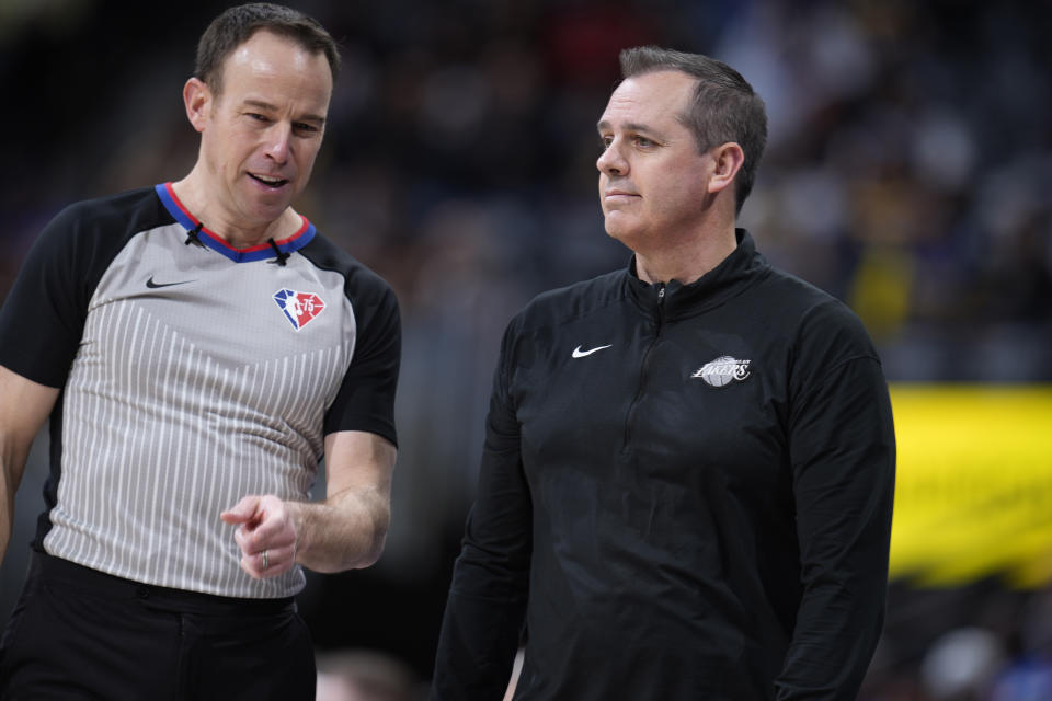 Referee Josh Tiven, left, confers with Los Angeles Lakers head coach Frank Vogel in the second half of an NBA basketball game Sunday, April 10, 2022, in Denver. (AP Photo/David Zalubowski)