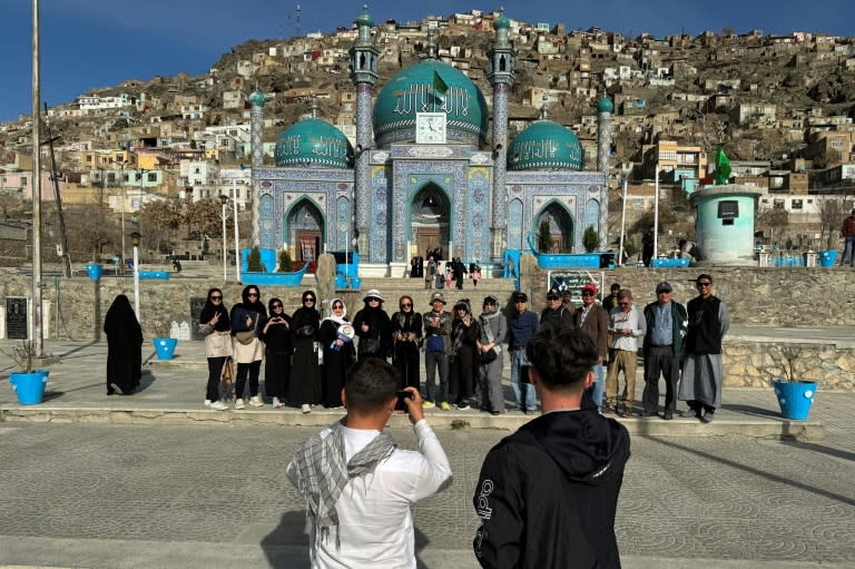 Des touristes thaïlandais posent pour une photo de groupe le 25 mars 2024 devant la mosquée Kart-e-Sakhi à Kaboul (Wakil Kohsar)