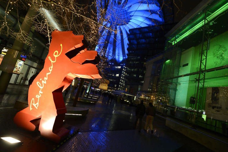 People walk by the giant logo of the Berlinale film festival in Berlin, on February 7, 2013. The 63rd Berlin film festival got off to a fists-flying start Thursday with Chinese director Wong Kar Wai's lush martial arts epic about the mentor of kung fu superstar Bruce Lee