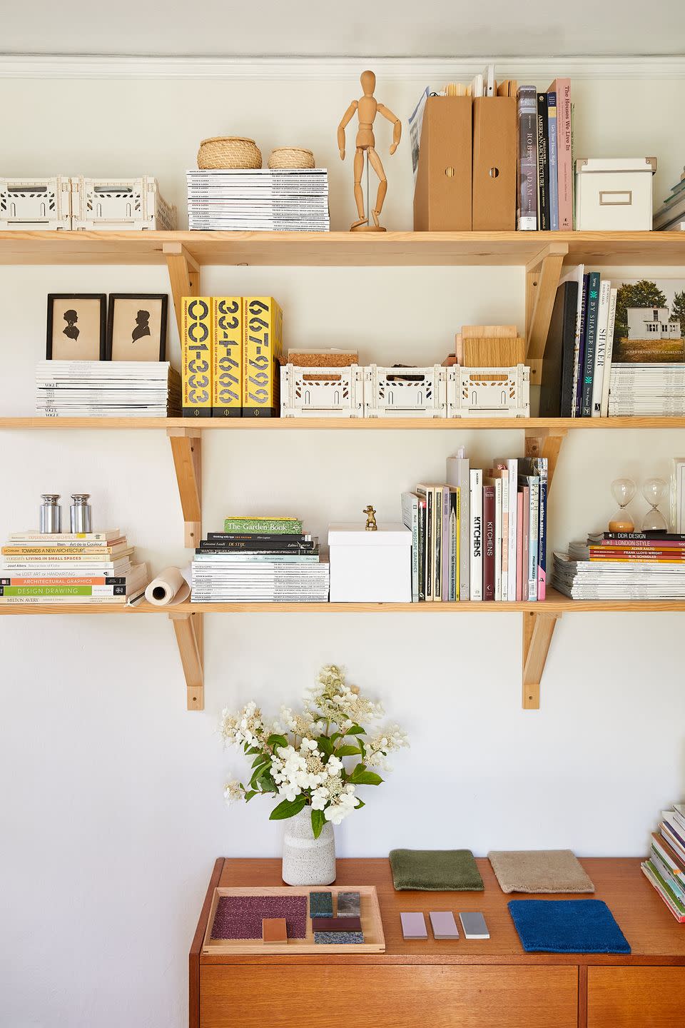 a bookshelf with books and a vase of flowers