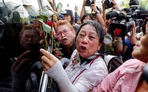 Supporters of ousted former Thai prime minister Yingluck Shinawatra react while wait for her at the Supreme Court in Bangkok, Thailand  - Credit: REUTERS
