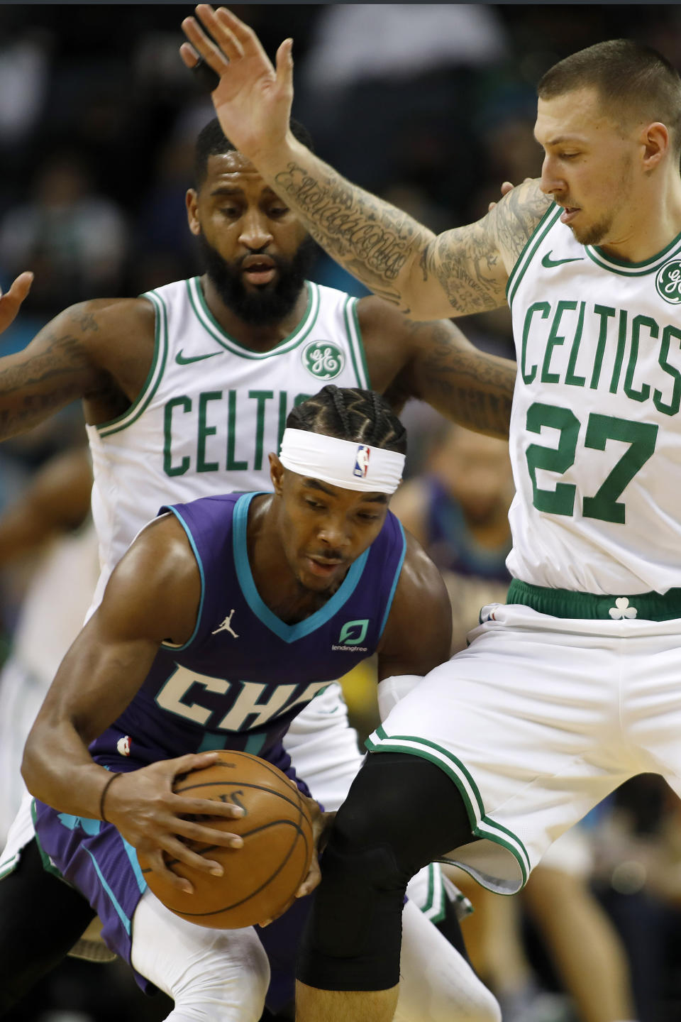 Charlotte Hornets' Devonte' Graham (4) tries to hold possession as he is double teamed by Boston Celtics' Brad Wanamaker, back and Daniel Theis (27), right, during the first half of an NBA basketball game in Charlotte, N.C., Tuesday, Dec. 31, 2019. (AP Photo/Bob Leverone)