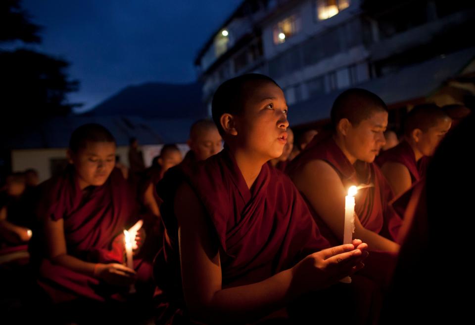 Exiled Tibetans participate in a candlelit vigil protesting the demolition of buildings by Chinese authorities in Larung Gar, one of the world's largest centers of Tibetan Buddhist learning, at a solidarity meet in Dharmsala, India, Wednesday, Oct. 19, 2016.