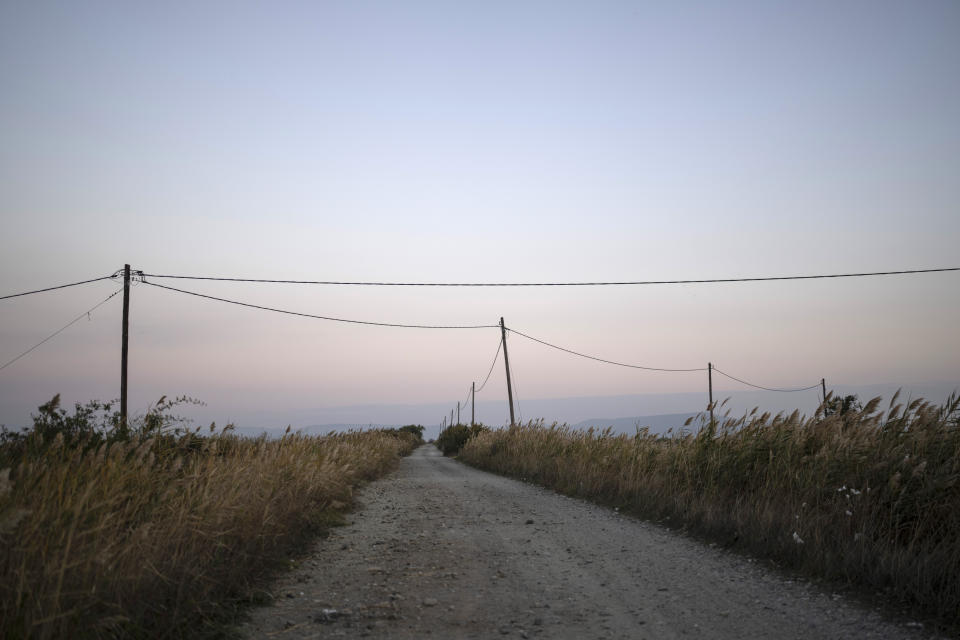 A road among wheatfields is seen in Evros region Greece, on Monday, Oct. 31, 2022. Greece is planning a major extension of a steel wall along its border with Turkey in 2023, a move that is being applauded by residents in the border area as well as voters more broadly. (AP Photo/Petros Giannakouris)