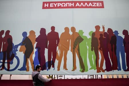 A worker sets a banner for a pre-election campaign rally of opposition radical leftist Syriza party in Athens January 22, 2015. REUTERS/Marko Djurica