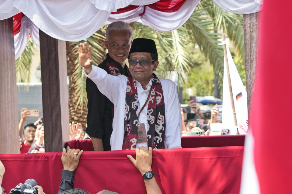 Presidential candidate of the ruling Indonesian Democratic Party of Struggle (PDIP) Ganjar Pranowo, left, and his running mate Mohammad Mahfud, popularly known as Mahfud MD, greet supporters after officially registering their candidacy to run in the 2024 presidential election at the General Election Commission building in Jakarta, Indonesia, Thursday, Oct. 19, 2023. The world's third-largest democracy is set to vote in simultaneously legislative and presidential elections on Feb. 14, 2024. (AP Photo/Achmad Ibrahim)