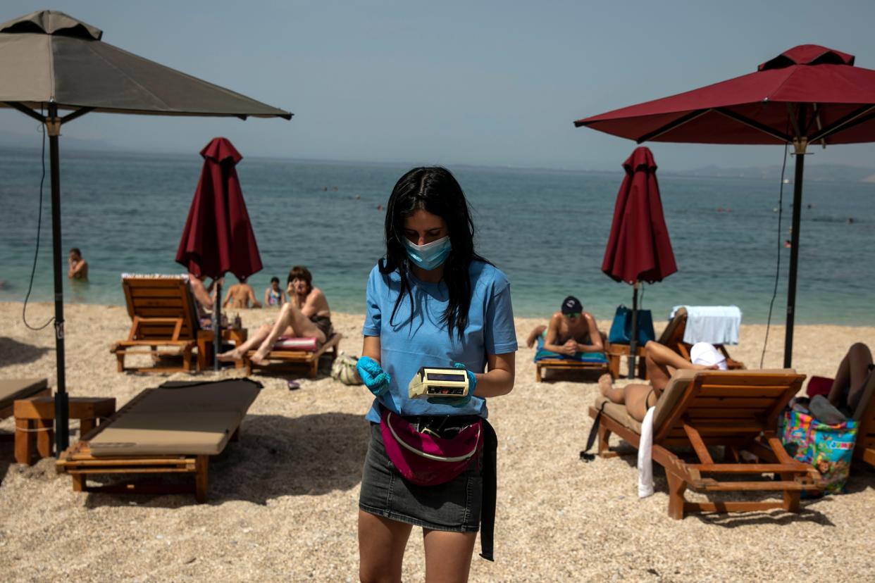 <p>An employee on a beach in Greece</p> (AP)