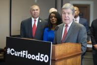 Rep. William Lacy Clay, D-Mo., left, and Judy Pace Flood, stand as Sen. Roy Blunt, R-Mo., right, speaks during a news conference as they call for the late Curt Flood to be inducted into the Baseball Hall of Fame, on Capitol Hill, Thursday, Feb. 27, 2020 in Washington. (AP Photo/Alex Brandon)