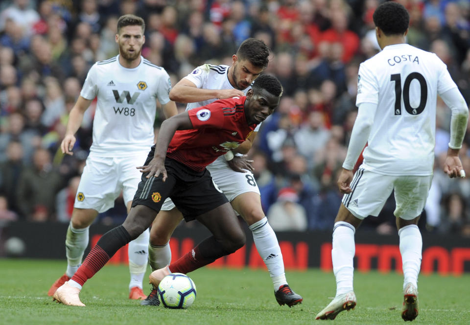 Manchester United's Paul Pogba fights for the ball with Wolverhampton Wanderers' Ruben Neves, background, during the English Premier League soccer match between Manchester United and Wolverhampton Wanderers at Old Trafford stadium in Manchester, England, Saturday, Sept. 22, 2018. (AP Photo/Rui Vieira)