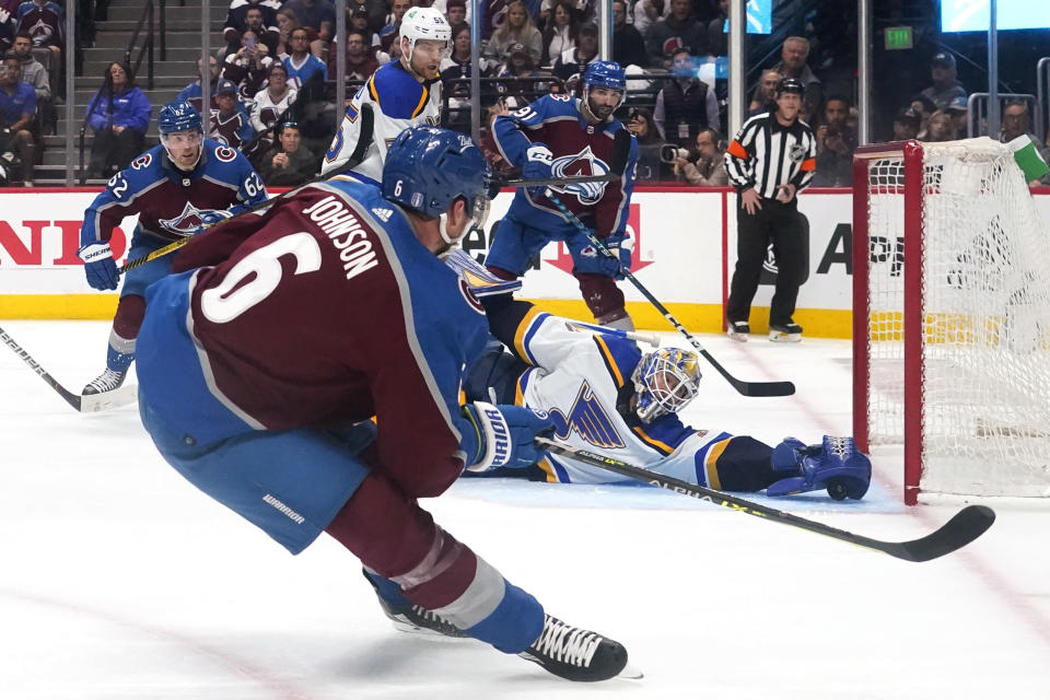 St. Louis Blues goaltender Jordan Binnington (50) makes a save against Colorado Avalanche defenseman Erik Johnson (6) during the second period in Game 1 of an NHL hockey Stanley Cup second-round playoff series Tuesday, May 17, 2022, in Denver. (AP Photo/Jack Dempsey)