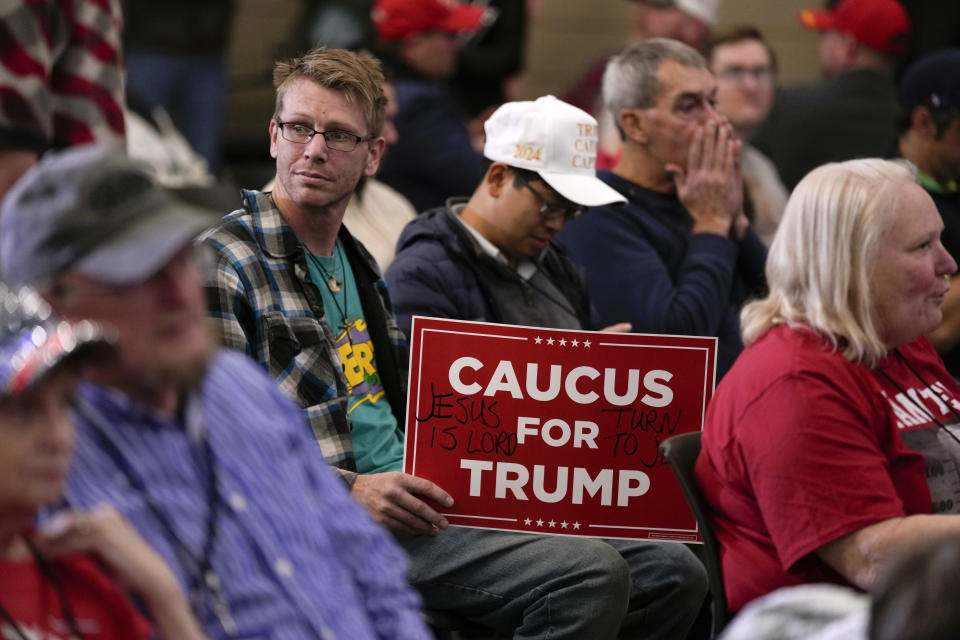 Audience members wait for former President Donald Trump to arrive at a commit to caucus rally, Tuesday, Dec. 19, 2023, in Waterloo, Iowa. (AP Photo/Charlie Neibergall)