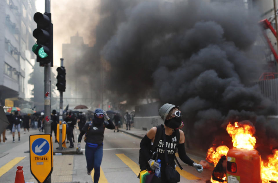 Protestors take cover in Hong Kong, Oct. 1, 2019. A Hong Kong police official says a pro-democracy protester was shot when an officer opened fire with his revolver during clashes. (Photo: Gemunu Amarasinghe/AP)