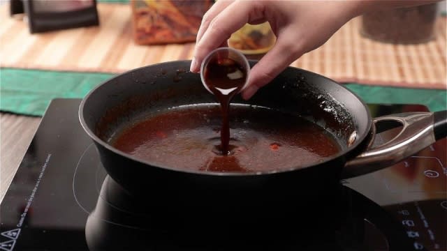 Adding waist tonic essence to sauce in pan