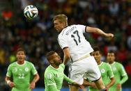 Germany's Per Mertesacker (C) jumps for the ball past Algeria's Islam Slimani (2nd L) during their 2014 World Cup round of 16 game at the Beira Rio stadium in Porto Alegre June 30, 2014. REUTERS/Darren Staples