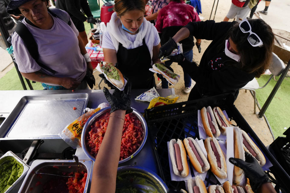 Volunteers feed those affected by forest fires in Vina del Mar, Chile, Tuesday, Feb. 6, 2024. (AP Photo/Esteban Felix)