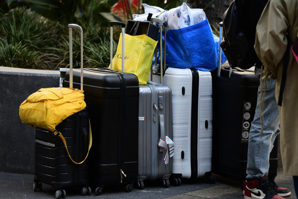 Resident's luggage is seen outside the Mascot Towers building in Mascot on Saturday. Residents of the high-rise have been evacuated as a precaution after cracks were discovered in the building.(AAP Image/Bianca De Marchi) 