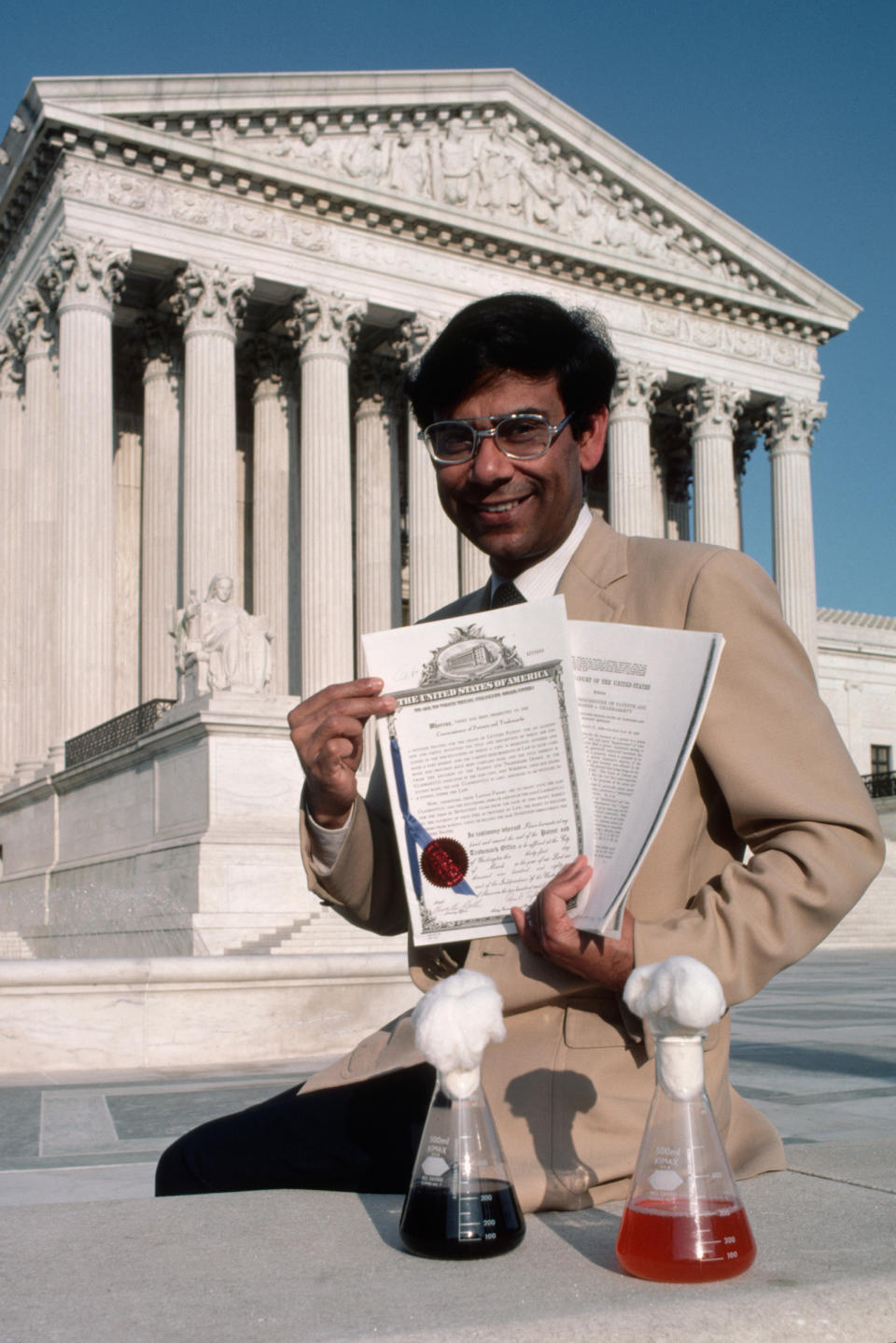 In front of the Supreme Court of the United States, Dr. Ananda Chakrabarty displays a trio of souvenirs of his pioneering experiments with a recombinant DNA created oil spill-eating bacteria.